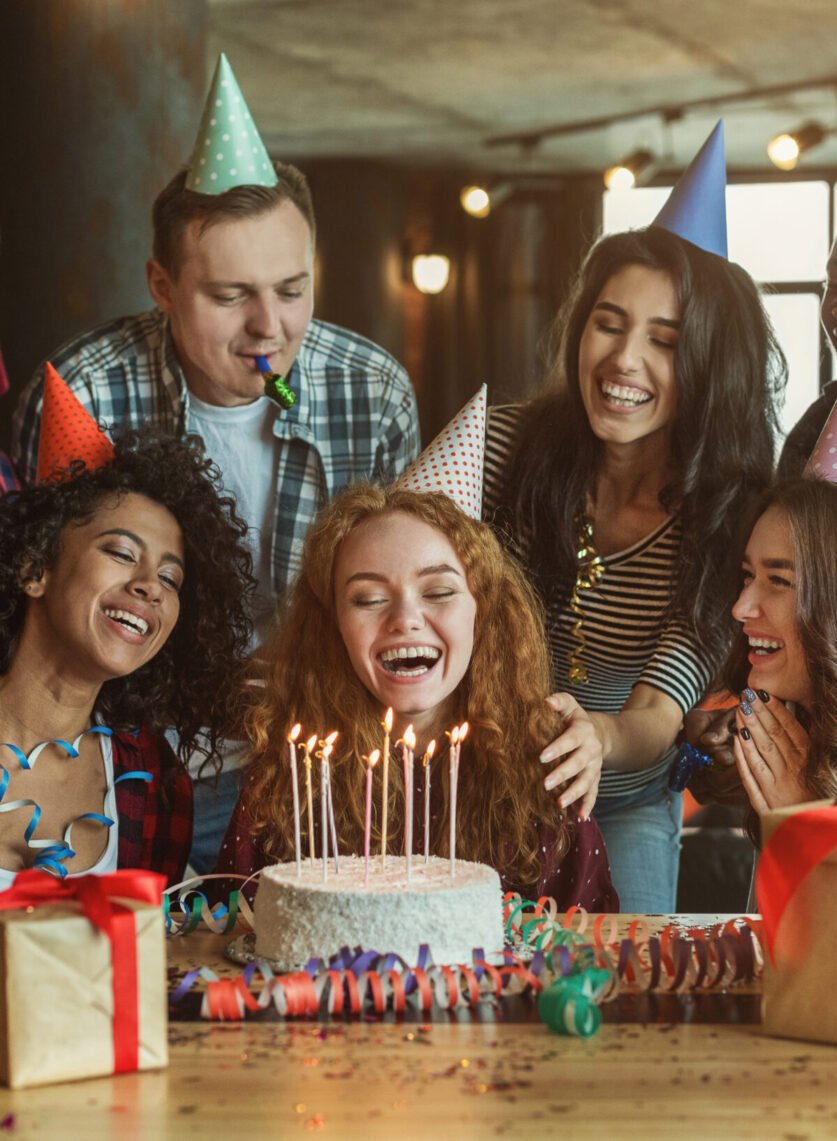 Happy friends congratulating girl on surprise birthday party, copy space