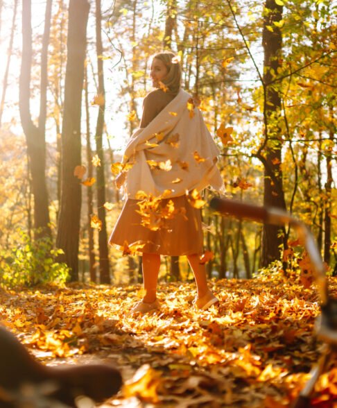 ?appy young woman having fun with leaves in autumn park.